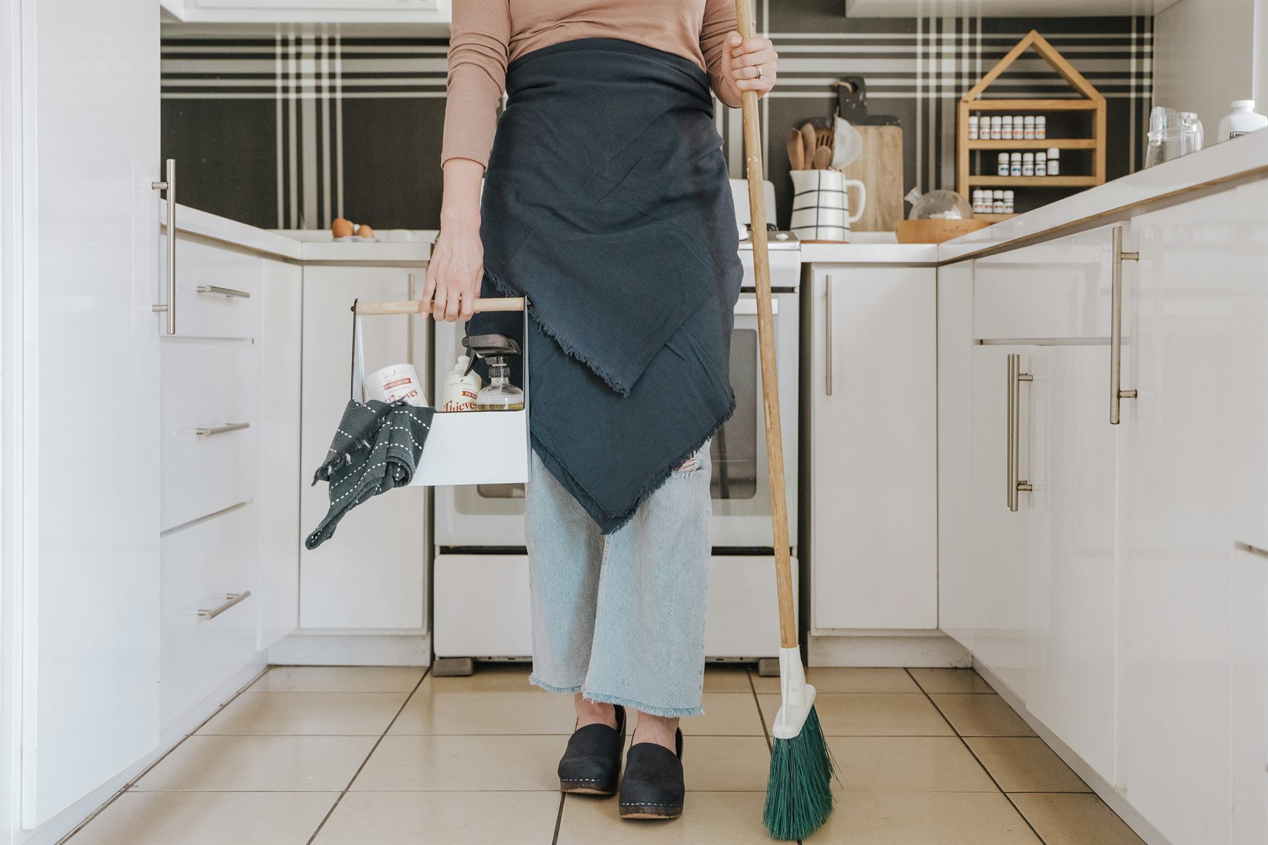 A cleaner sweeping the floor in a kitchen