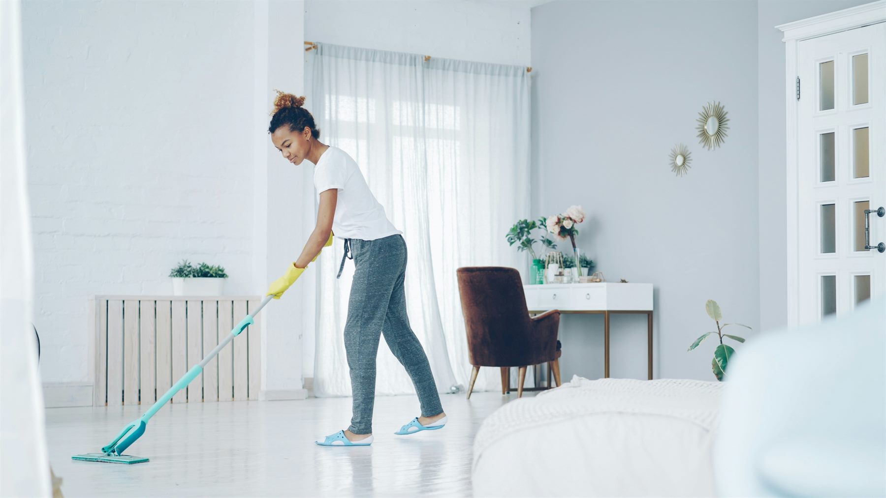 A cleaner mopping the floor in a bright home