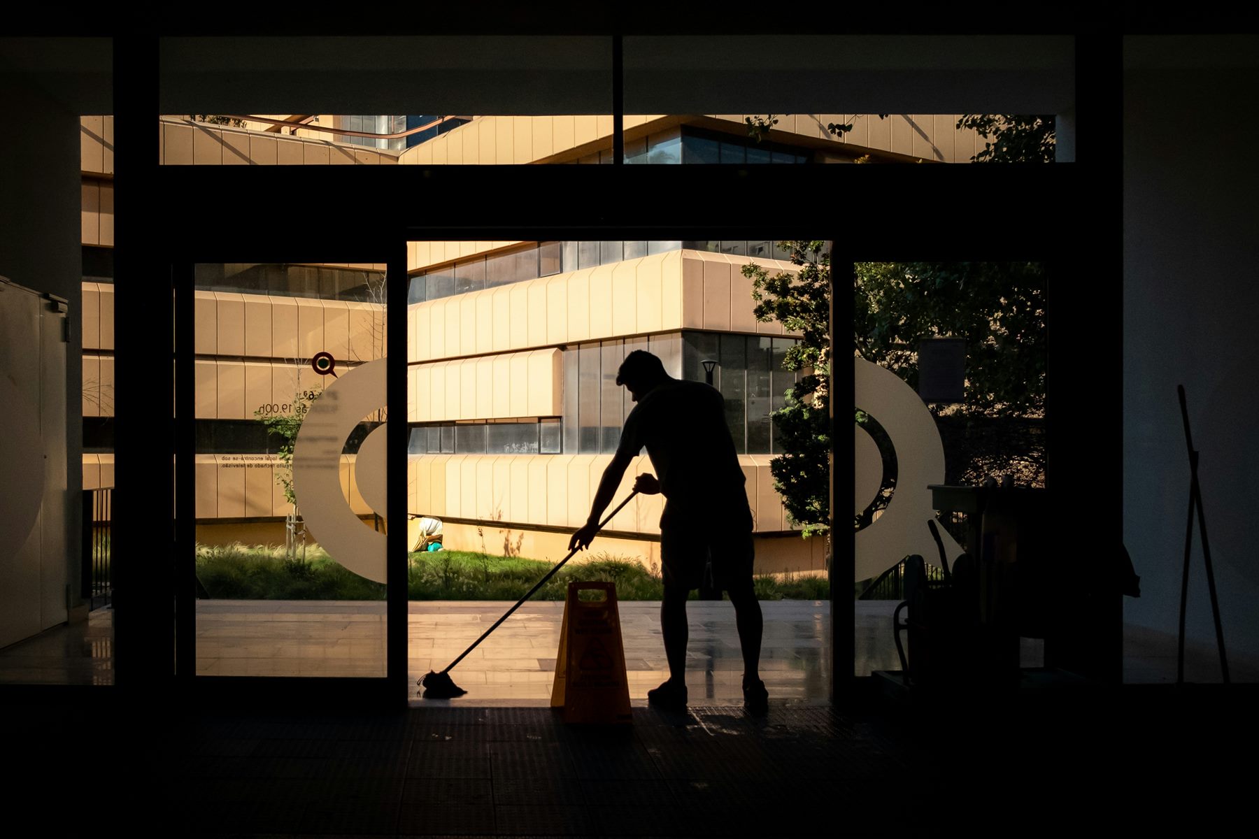 A cleaner mopping the floor of a commercial building
